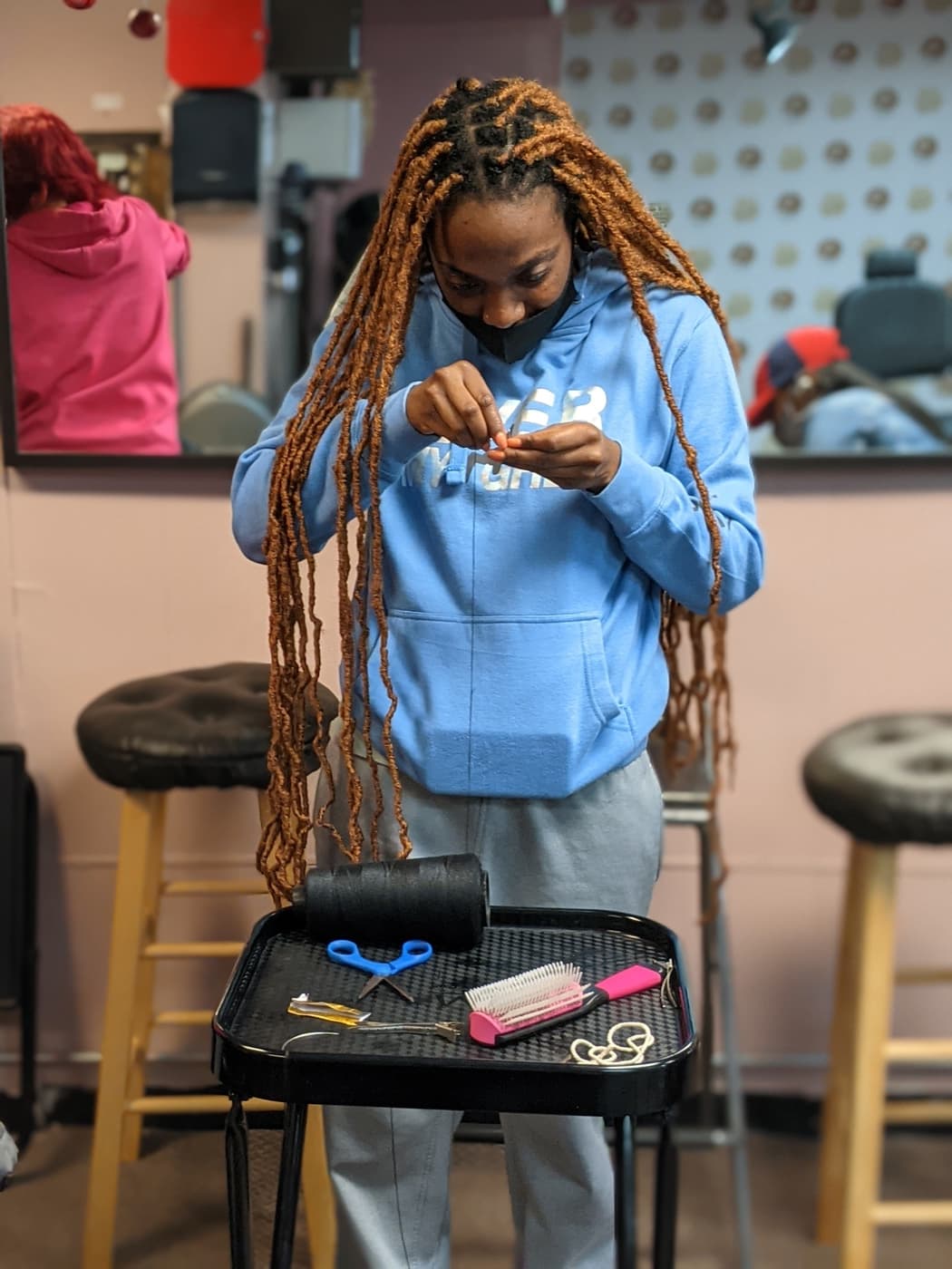Student preparing extensions and tools for goddess locs